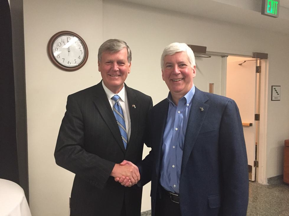 President Thomas J. Haas (left), shakes hands with Gov. Rick Snyder; Haas was appointed to Snyders education commission.